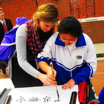 High school teens co-writing a chinese calligraphy in the language program 