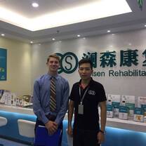 intern in healthcare company from internship in china program taking a photo with his supervisor before the frontdesk
