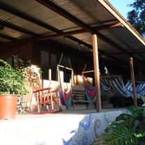 A few chairs and hammocks on a porch