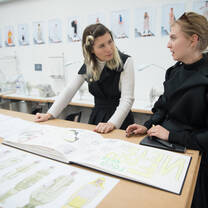 Student getting feedback from a tutor on a sketch book
