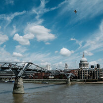St Paul's Cathedral and bridge over the river Thames, blue sky above.