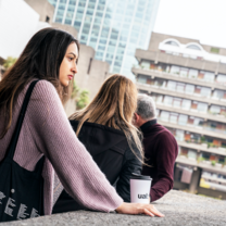 Image of student with a UAL cup in front of the Barbican