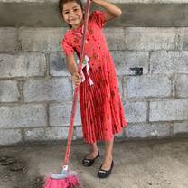 Donã Socorro's little daughter helps sweep the inside of her new home.