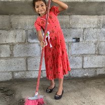 Donã Socorro's little daughter helps sweep the inside of her new home.