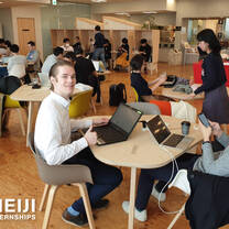 Meiji Intern at work in front of a computer with other interns