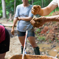 Hands in the mud building a natural home