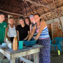 Volunteers learning how to make cheese from local mother, Sara