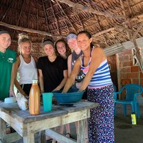 Volunteers learning how to make cheese from local mother, Sara