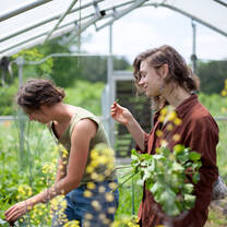 Smiling with flowers in the greenhouse