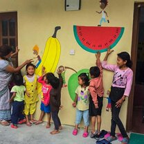 Young kids at school in front of a bright wall