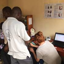 Volunteers helping to take vitals on children. 