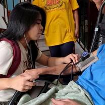 A volunteer helping to take vitals. 