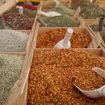 Rows of vibrant spices with scoops placed inside of them 