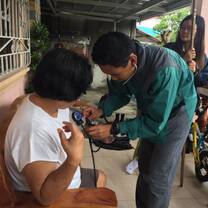 A volunteer helping to take vitals on  house-to-house health visits.