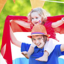Young teen boy with little sister on shoulders—both with Dutch colors