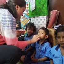A volunteer distributing vitamins to malnourished children at the creche. 