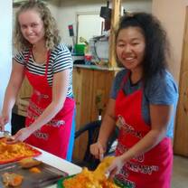 Volunteers Lucy and Takara preparing food on the Feeding project
