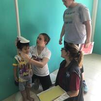A volunteer measuring the height of children in our nutrition program. 