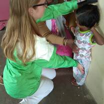 A volunteer measuring height of a child at a creche. 