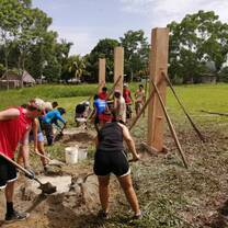 Students assembling the frame and digging to form the cafeteria of the community center 