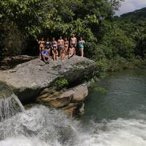 Students swimming in the waterfall of the Rio Blanco National Park