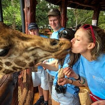 Giraffe kisses student in Kenya with Culsans.