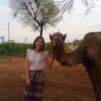 Female volunteer in India having a fun time with camel
