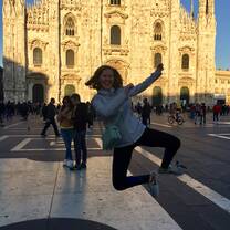 A student is photographed jumping in the Piazza del Duomo with the famous cathedral in the background.