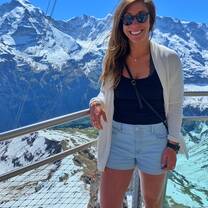 Standing on a clear, glass bridge over the Swiss Alps on the Schilthorn mountain with the famous Eiger Mountain in the background