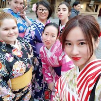 6 people posing at a shrine in very colorful winter kimono's