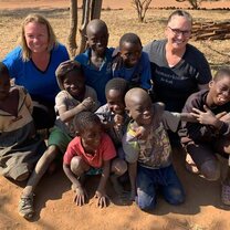 Village Book Builders volunteers smiling with Kenyan children.