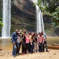 Volunteers in Kenya posing in front of scenic waterfalls.