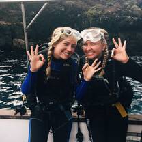 two girls smiling in galapagos about to go scuba diving