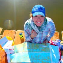 Female gap year participant smiling with a map and compass.