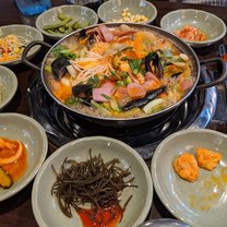 picture of a seafood soup with side dishes