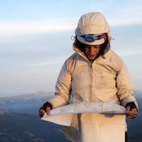 A student reads a map to navigate her crew to their next campsite.