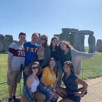 Visiting Stonehenge Wroxton College abroad students smiling at Stonehenge.