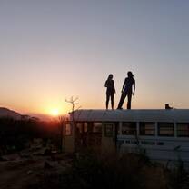 Two figures standing on top of a bus