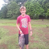 Teen boy stands with large Tilapia fish