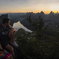 Two people watch the sunrise in Yangshuo
