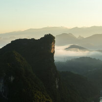 Mountains of Yangshuo Clouds drift behind a mountain peek