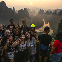 Students on a trip to a special mountain in Yangshuo Students infront of a sunrise on Husband Moutain