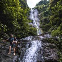 Pubutang Waterfall in Yangshuo Two girls walk bare foot near a waterfall