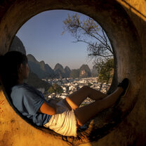 Yangshuo park's pagoda has some great spots to soak in views A girl sits looking out a window to Yangshuo