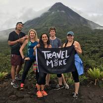 Standing in front of the Arenal volcano with the four other volunteers I lived with on a weekend adventure. We are holding a flag from the company Serengetee, that reads "Travel More."