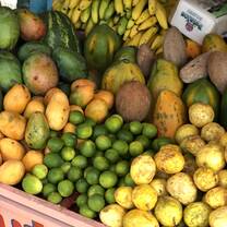 A smoothie stand in a town center with an array of fresh fruit. 