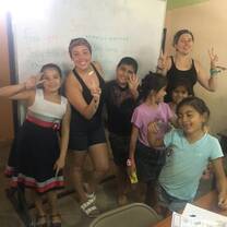 Standing in front of the white board in our classroom with my assistant teacher and 5 of our students holding up peace signs and being silly on the last day of class. 
