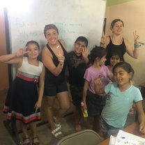 Standing in front of the white board in our classroom with my assistant teacher and 5 of our students holding up peace signs and being silly on the last day of class. 