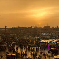 Eating dinner overlooking the Marrakech marketplace as the sun sets. 