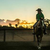 A girl rides with the back drop of the Australian sunset